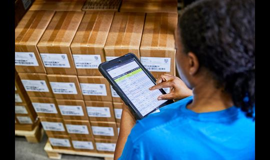Worker at distribution center checks boxes