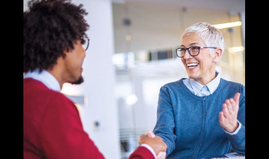 Woman and man shaking hands at job interview