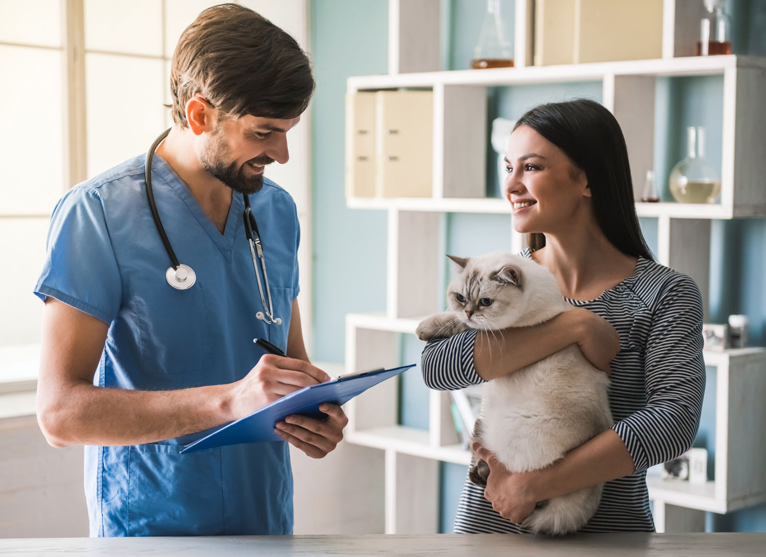 vet talking to woman holding her cat